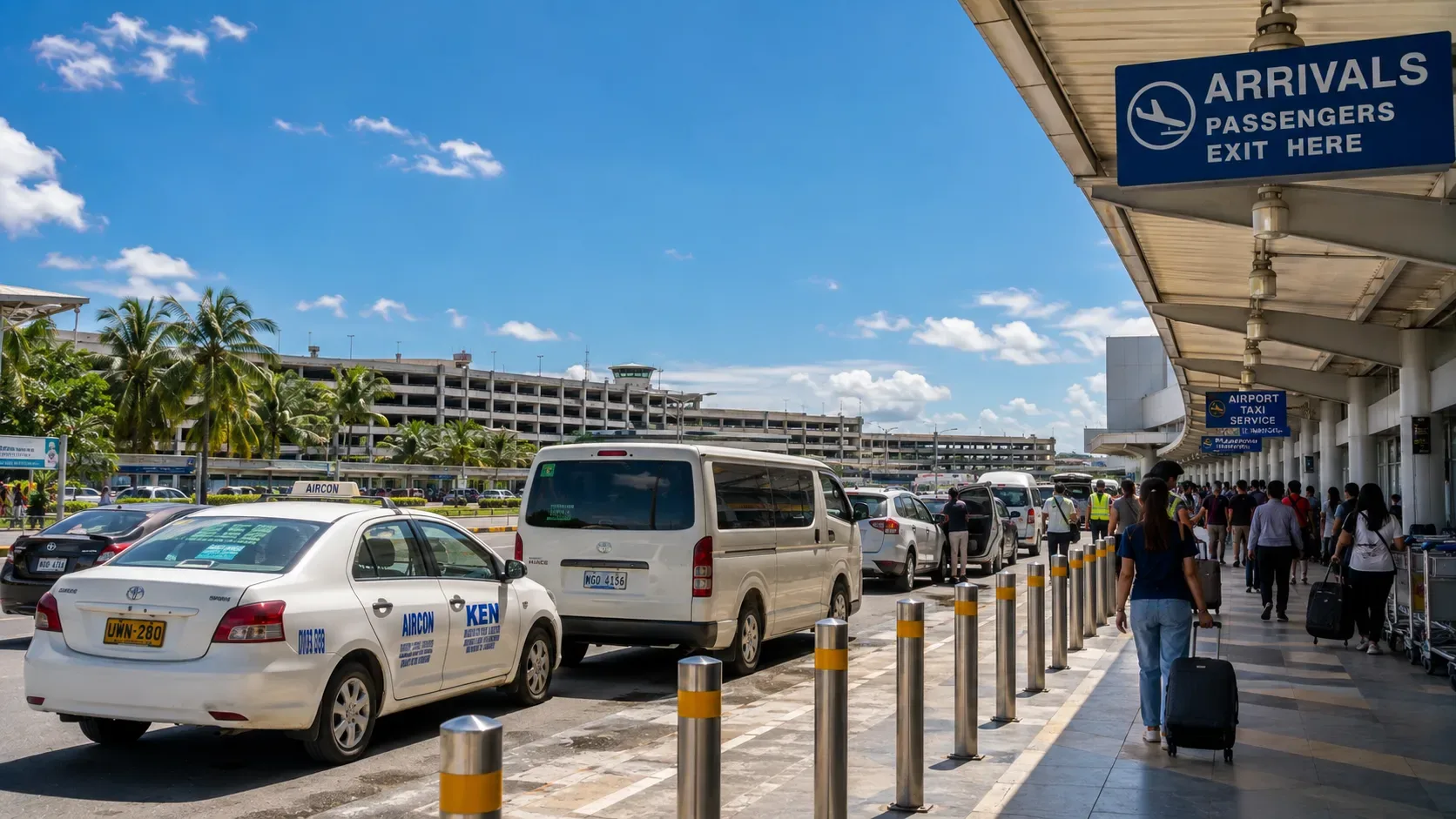 Le trottoir des arrivées d'un aéroport philippin, avec des taxis et des vans qui attendent.
