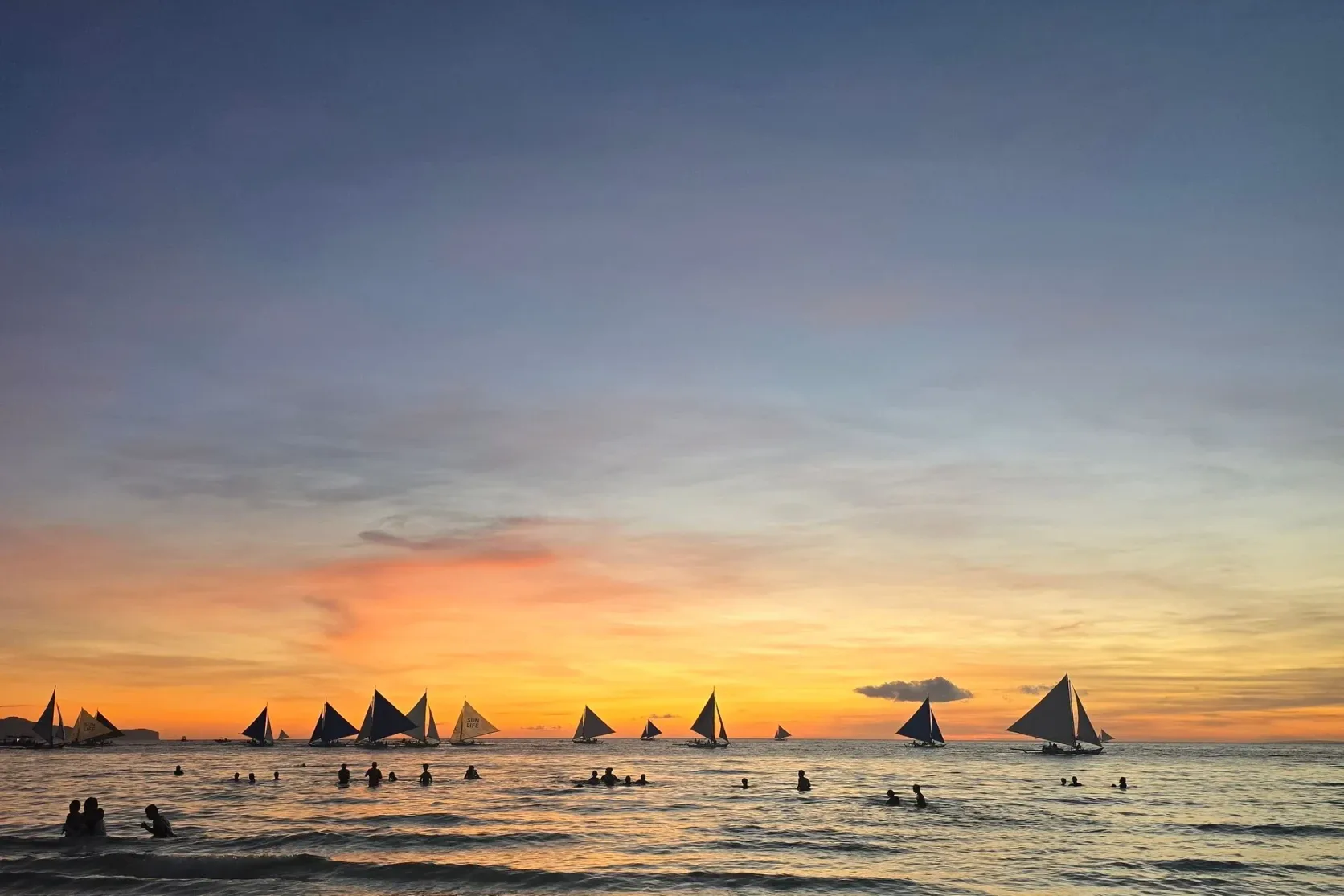 Des voiliers au large de White Beach, à Boracay, au coucher du soleil.