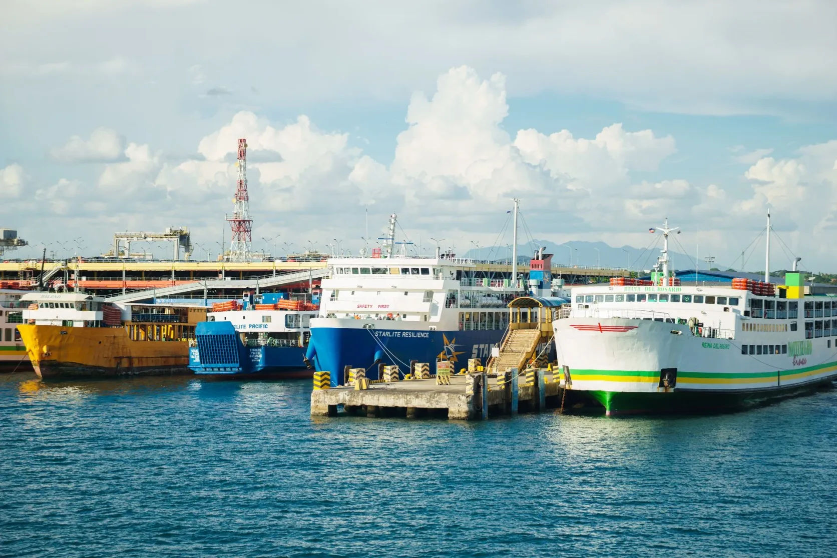 Des ferries de passagers à quai dans un port sous un ciel bleu.