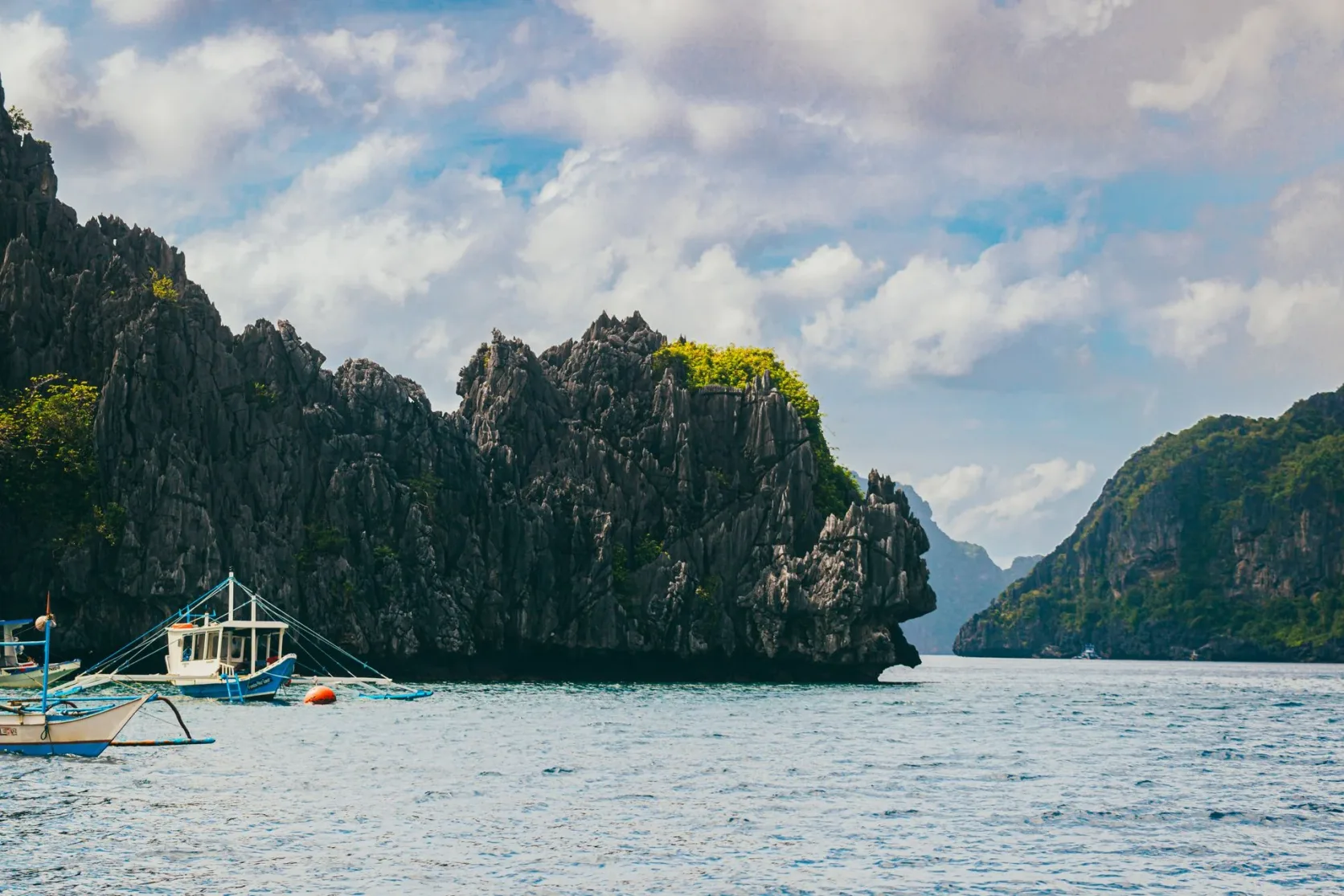 Des bateaux au pied des falaises calcaires d'El Nido.