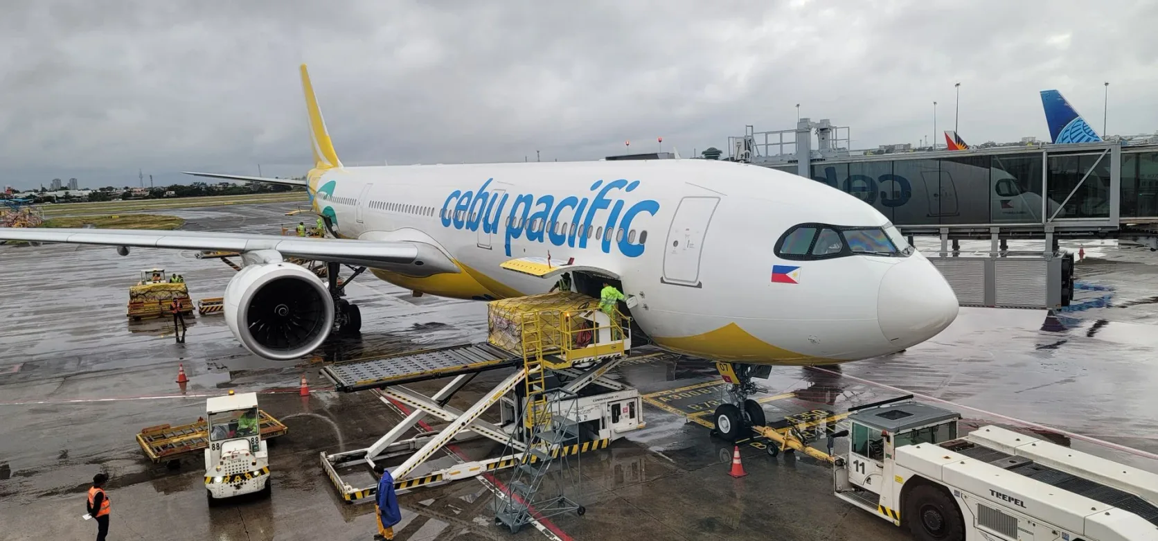 Un Airbus de Cebu Pacific en cours de chargement à la porte sous la pluie.