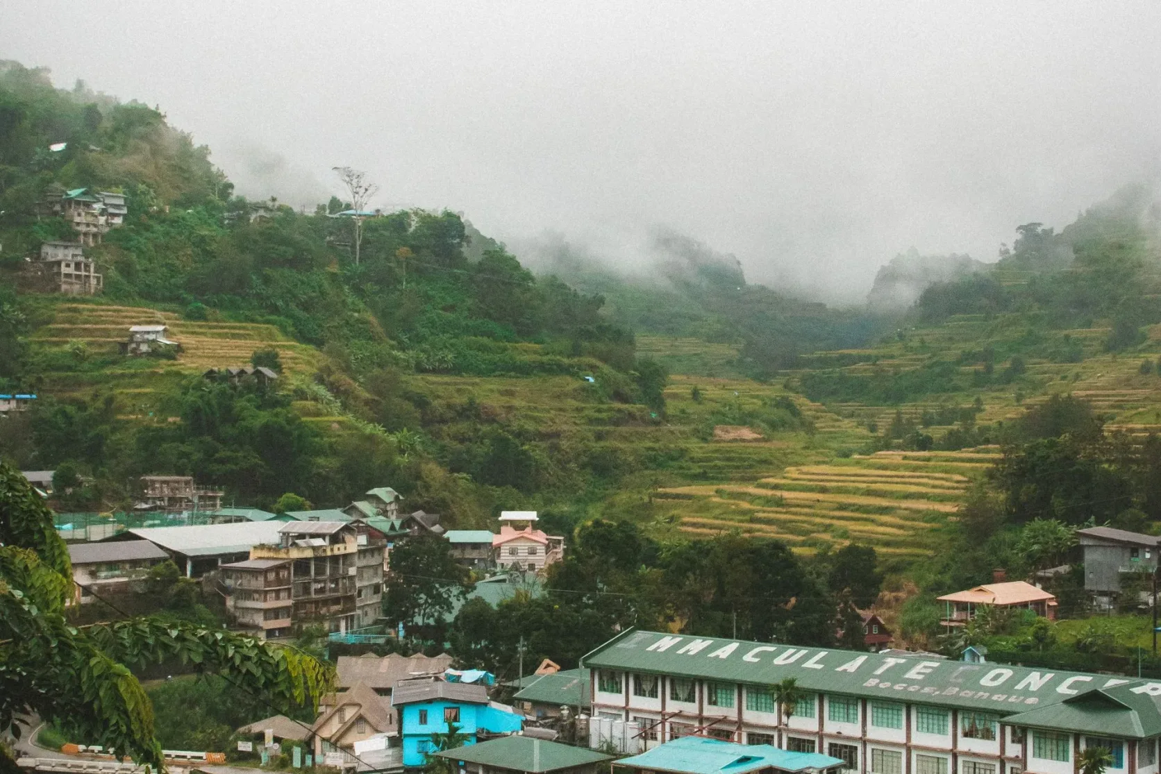 Le bourg de Banaue dans la brume, entouré de rizières en terrasses.