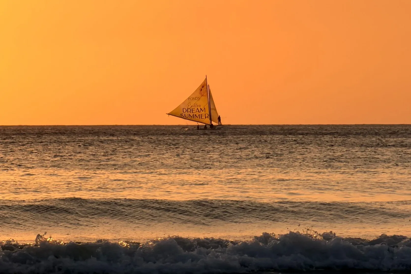 Un voilier sur une mer calme au large de Boracay au coucher du soleil.