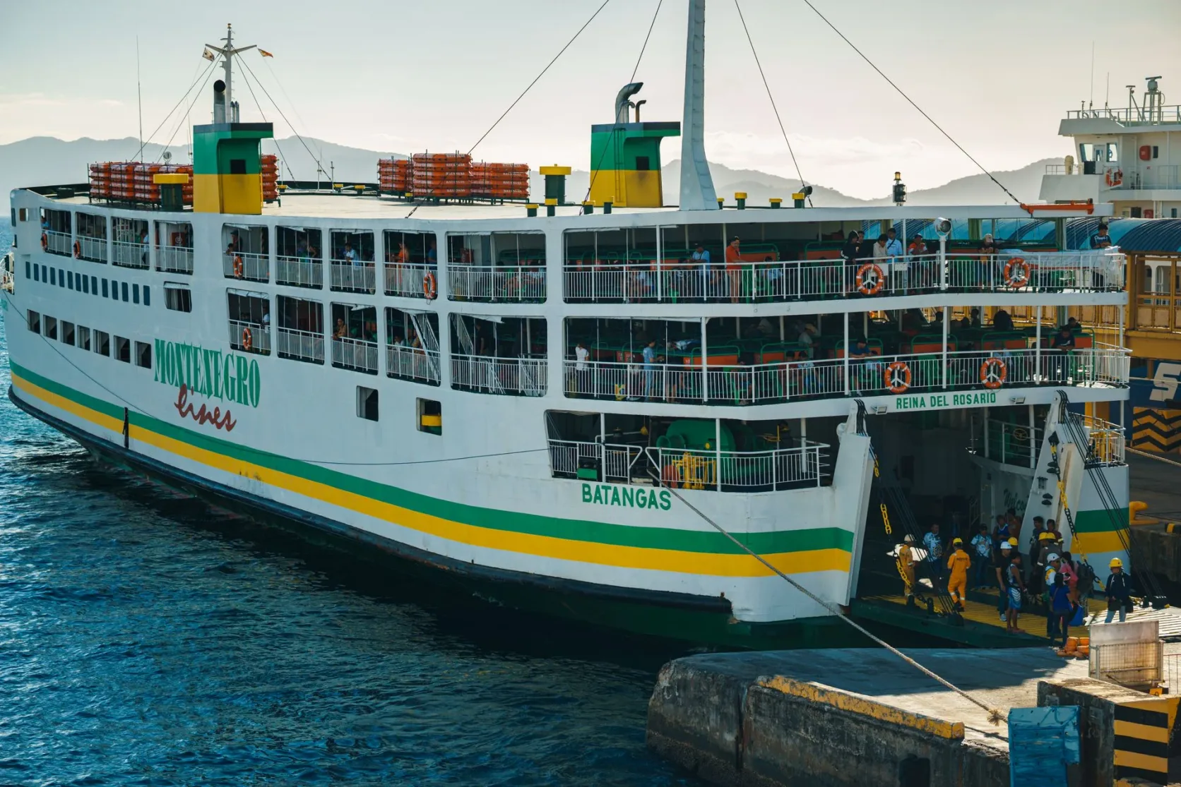 Un ferry accostant au port de Batangas pendant que des passagers débarquent.