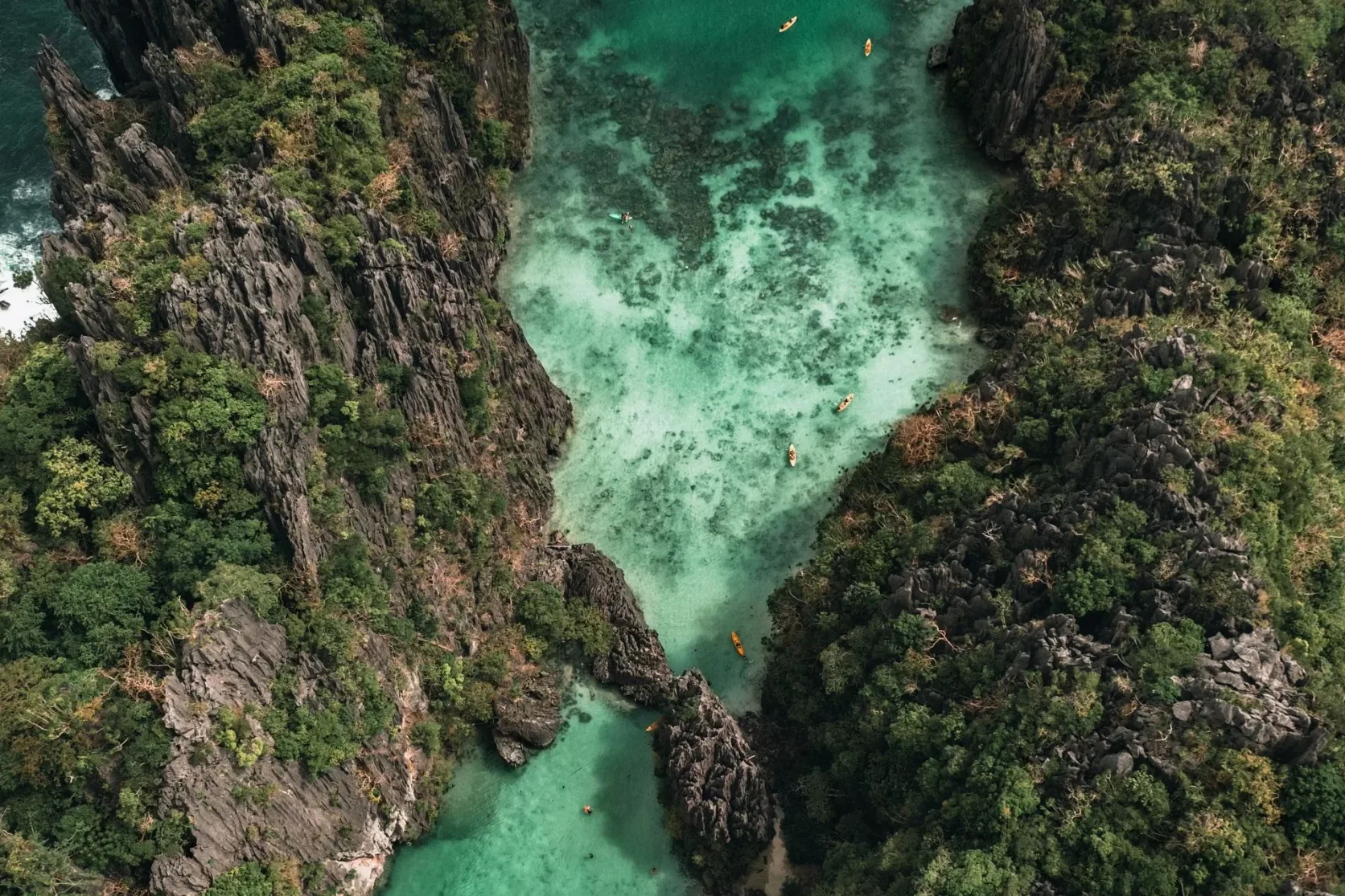 Des bateaux dans un lagon entre les falaises d'El Nido.
