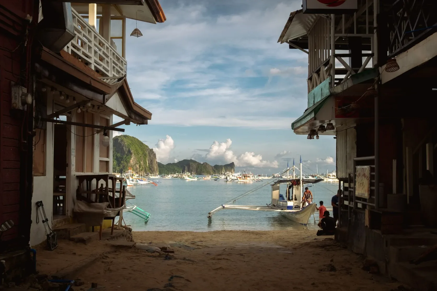 Bateaux et falaises vus depuis le front de mer d'El Nido.