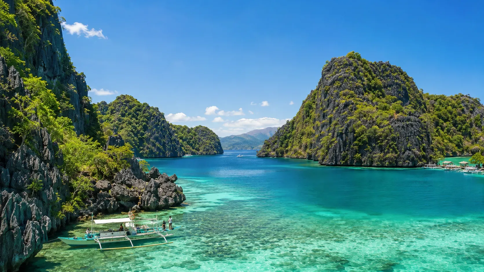 Le littoral du nord de Palawan, avec des falaises calcaires et des bateaux au large.