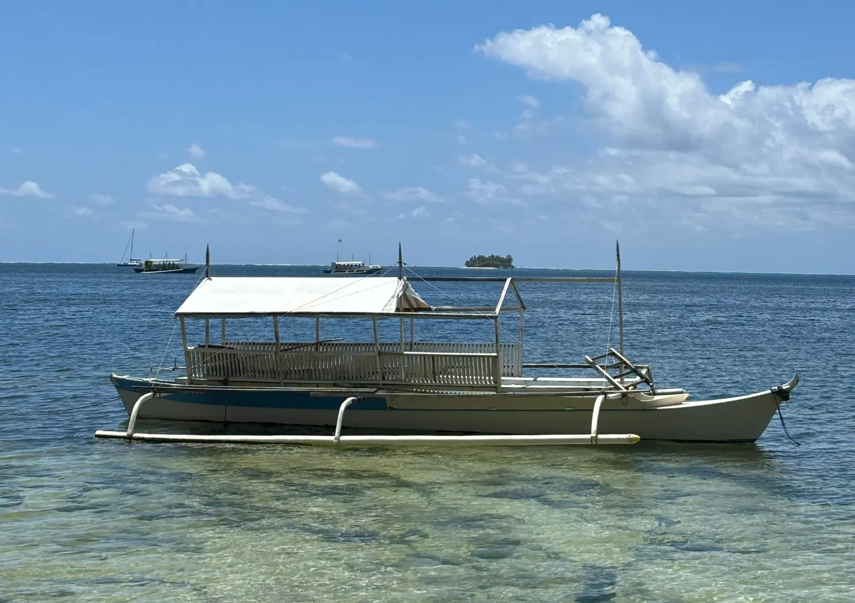 Un bateau à balancier amarré dans une eau claire au large de Siargao.