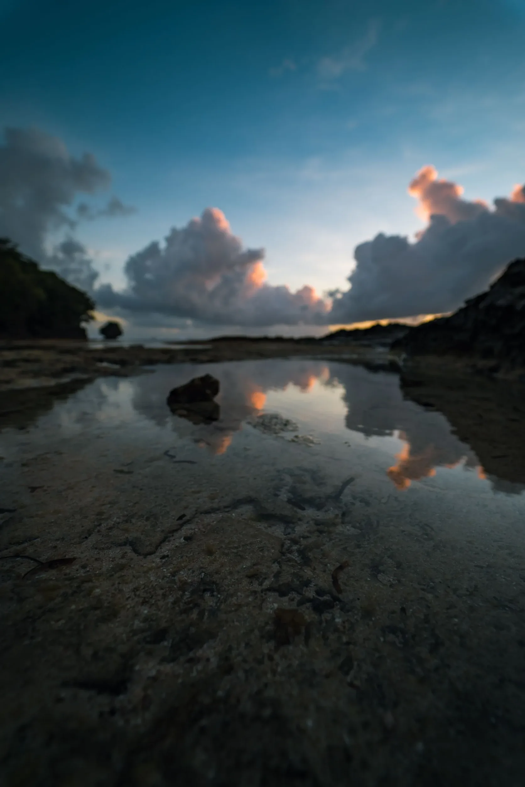 Coucher de soleil reflété dans les flaques d'une plage de Siargao.
