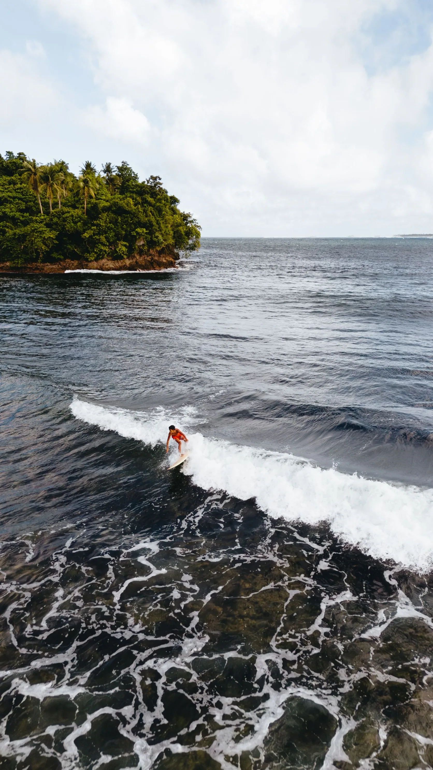 Un surfeur sur une vague au large de Pilar, à Siargao.