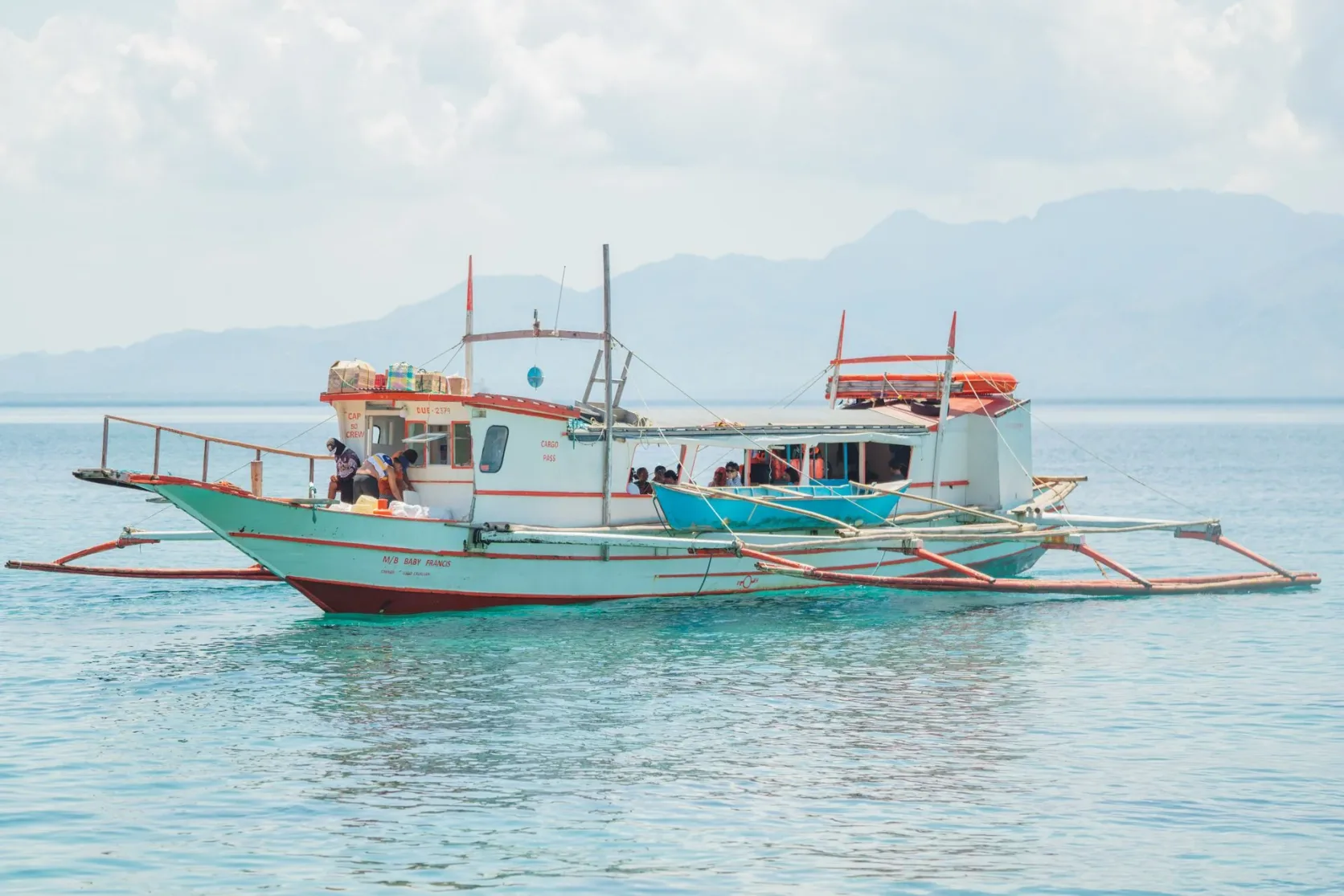 Une pirogue de pêche à balancier sur une mer tropicale calme.