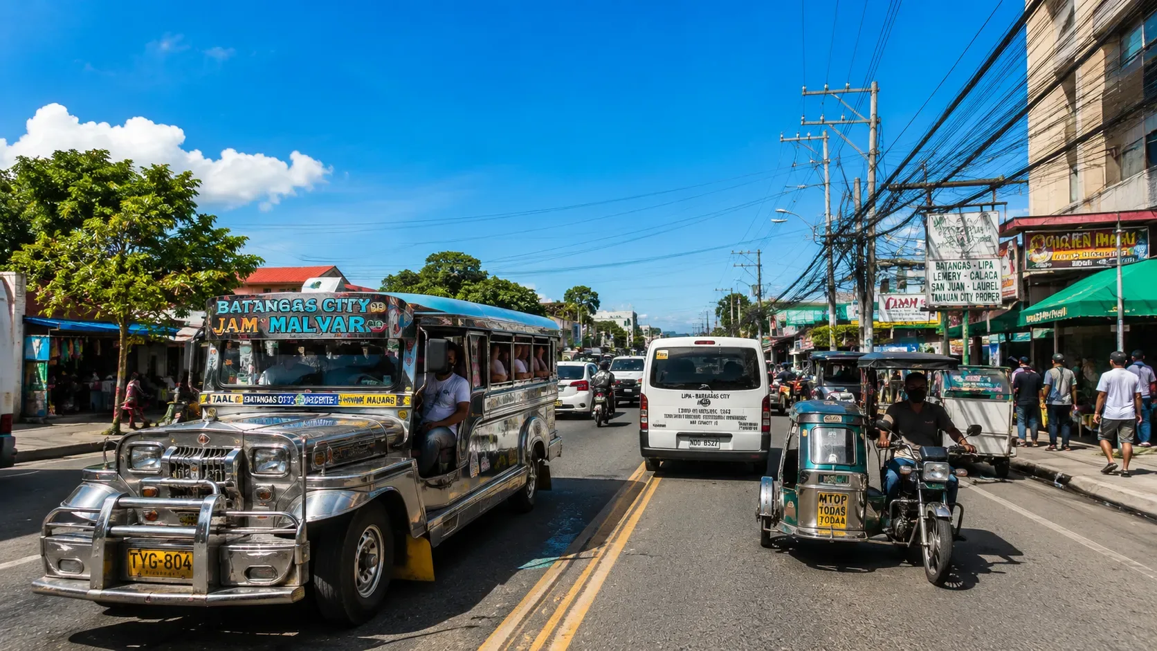 Une rue philippine avec un jeepney, un van et un tricycle dans la circulation.