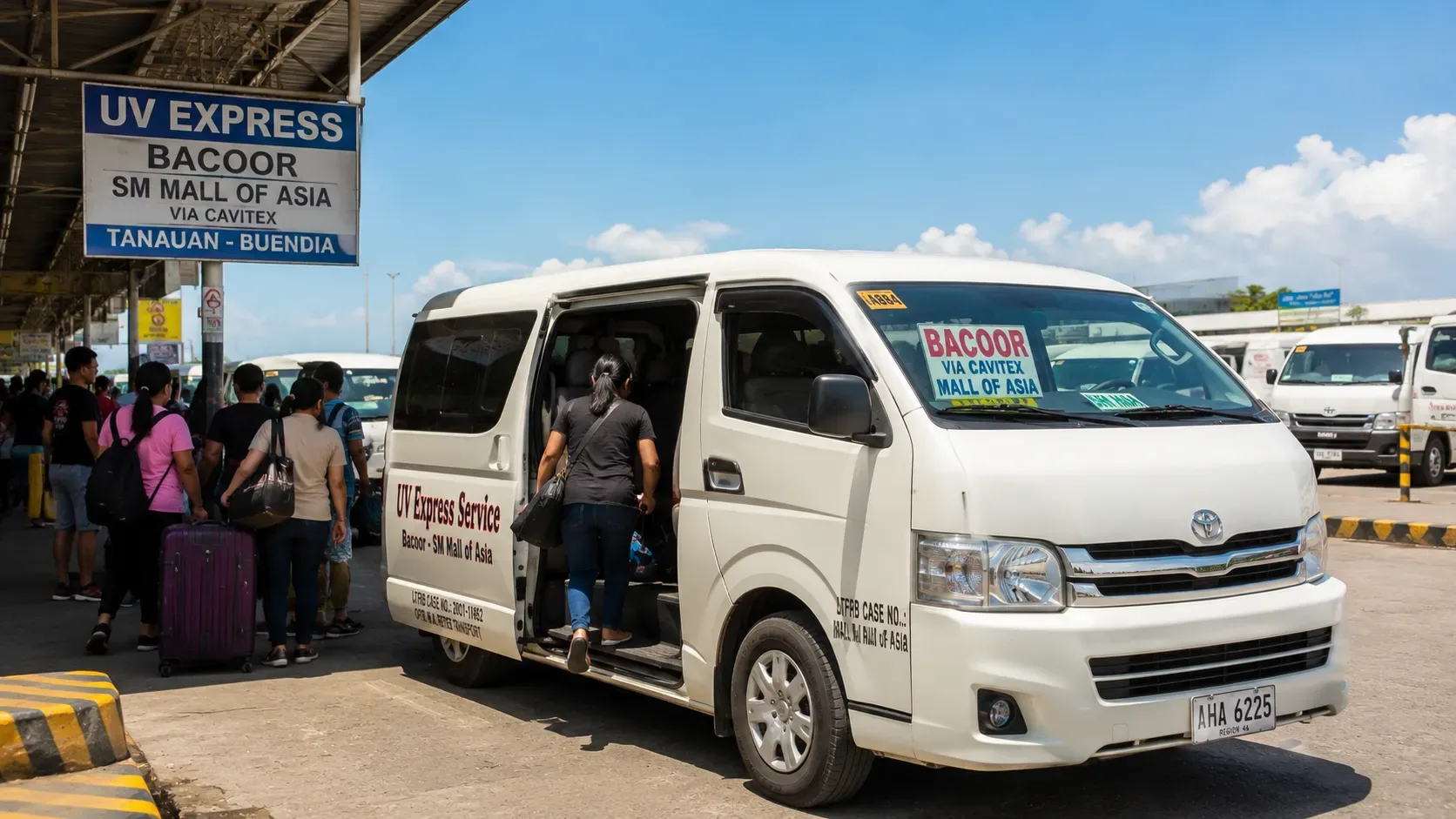 Un van UV Express embarquant des passagers dans un terminal.